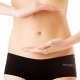 a woman's stomach with her hands over her belly